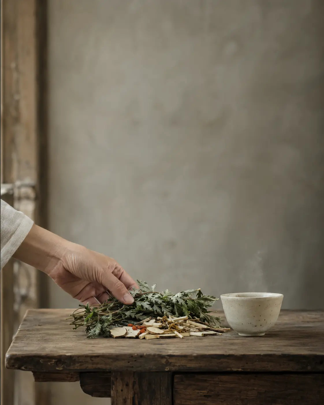 Herbs, tea and soft daylight on a wooden table